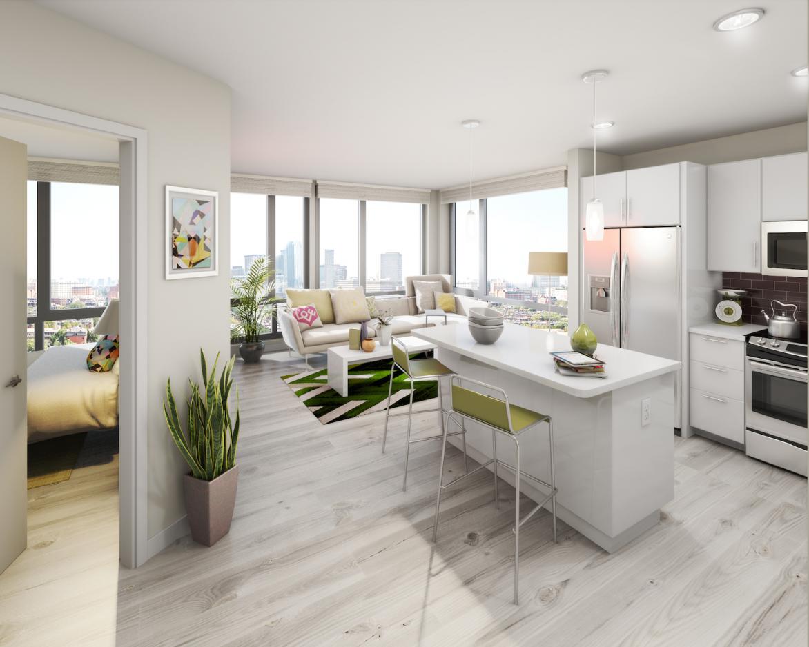Continuum South apartment with Kitchen, living room and open bedroom door in view. Light grey wood patterned floors, stainless steel appliances, plants, floor to ceiling windows