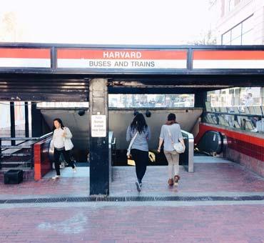 People entering and exiting "Harvard Busses and Trains" station