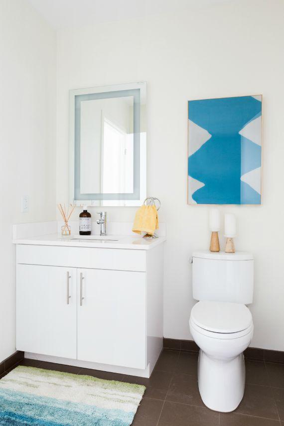 View of Contunuum North bathroom decorated with painting, floor mat, and amenities with a blue, white and yellow color scheme